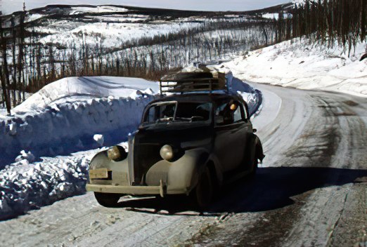 A car loaded down, and challenging the slick, winter highway. road in winter