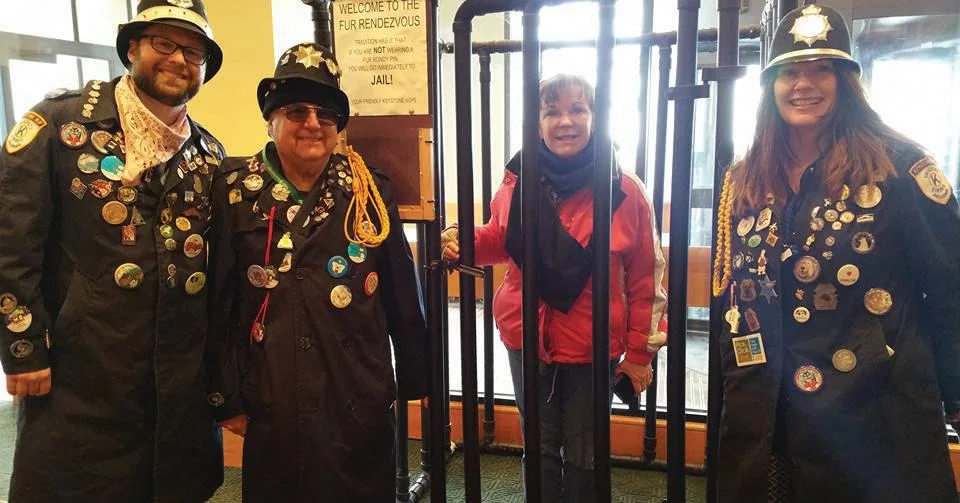 Fur Rendezvous Keystone Cops in Anchorage, Alaska having fun, pretending to lock up a lady who didn't have a Rondy button. fur rendezvous jail