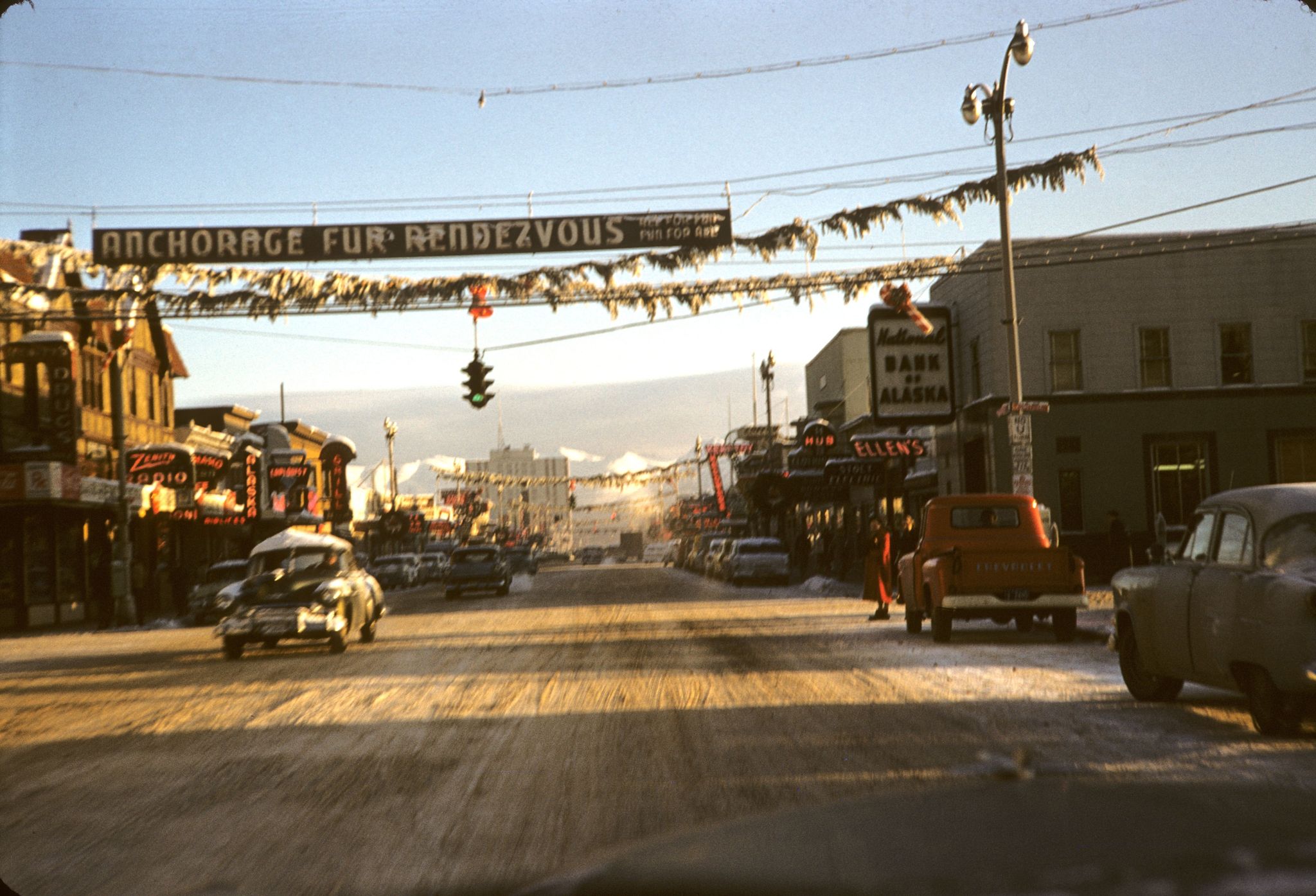 4th Avenue in Anchorage, Alaska in 1957. The Fur Rendezvous sign over the street is promoting the yearly winter festival. Fur Rondy 1957